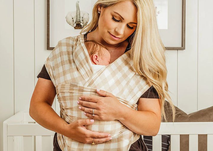 Mom snuggles baby in baby wrap carrier