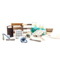 Baby product bundle on white background. Featuring baby glass food jars, nursing poncho, food pouches, thermos, baby spoons, silicone suction bowls, burp cloth, freezer tray, and baby food feeders.