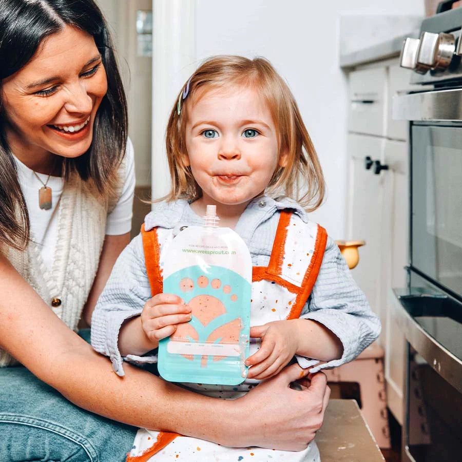Toddler eats smoothie out of reusable squeeze pouch