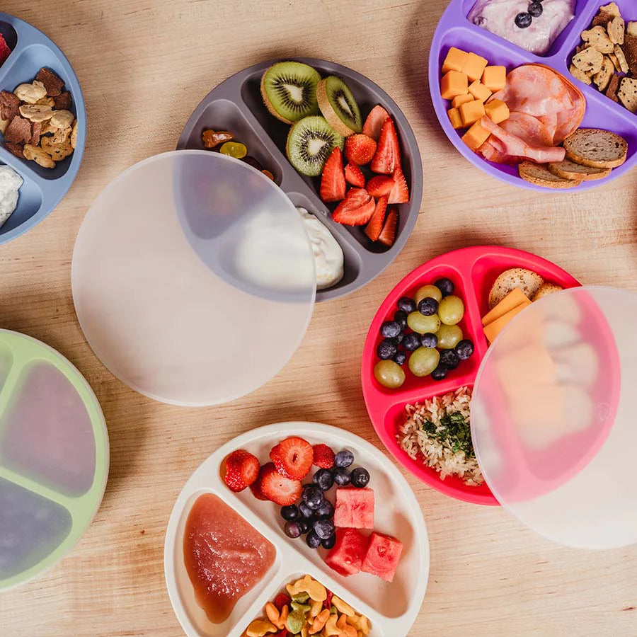 Multi colored silicone divided plates with lid featuring food like fruits, meats, and crackers