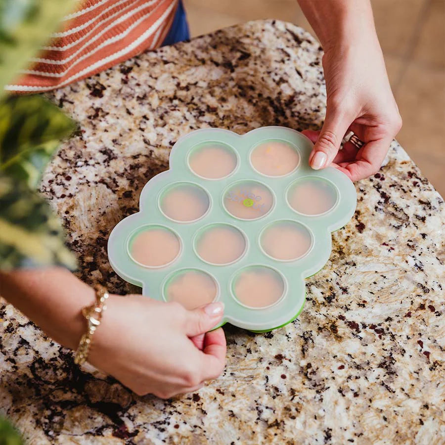 Woman puts top on silicone freezer tray with purree's inside