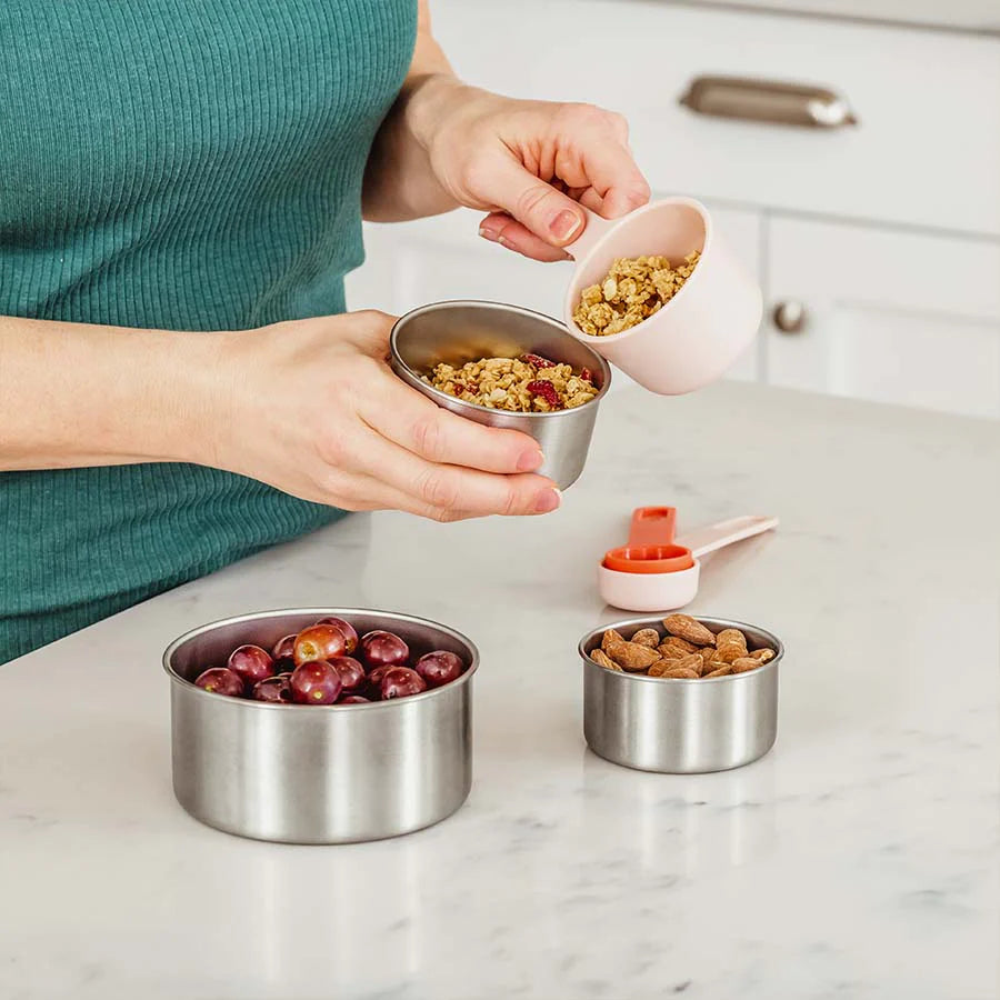 Mom measuring out snacks into the stainless steel storage containers