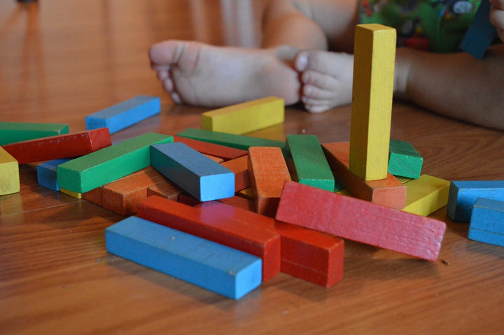 Differnt colored blocks with a child sitting behind them 