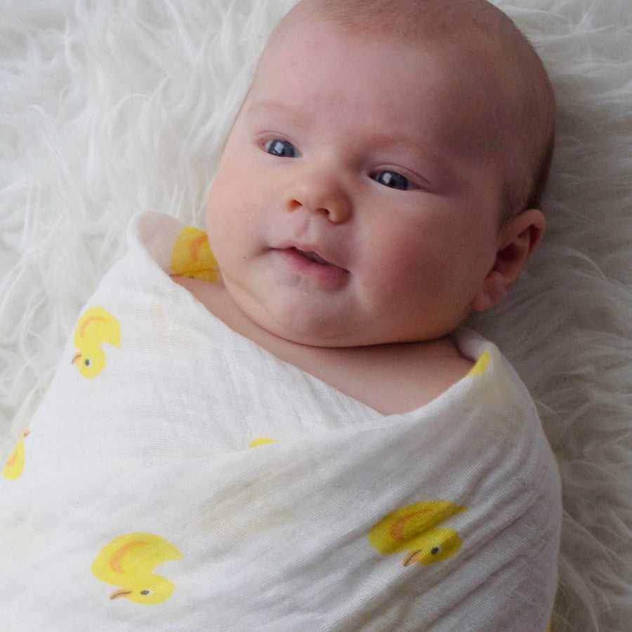 Baby Swaddled in an organic cotton blanket  with ducks imprinted on it