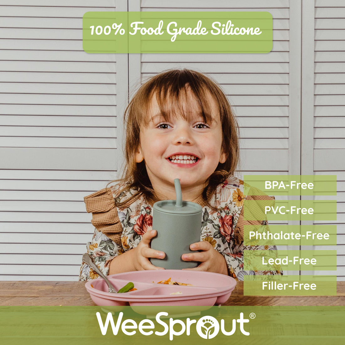 Child sitting at table with silicone divided plate and silicone straw cup.