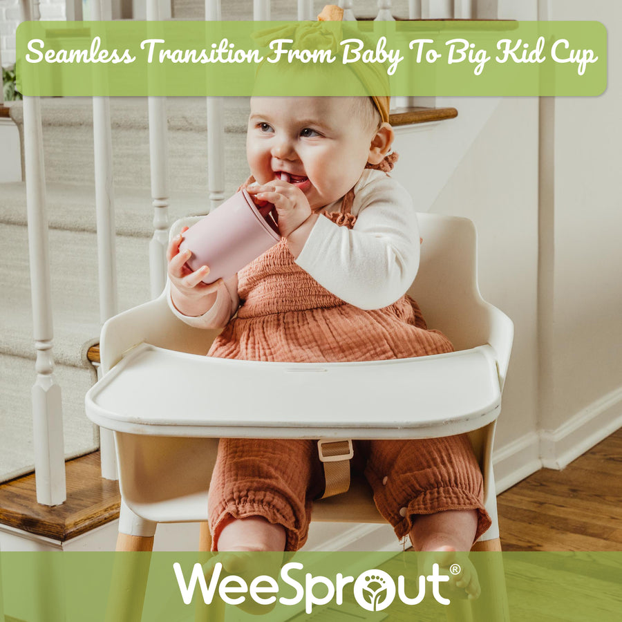 Baby in highchair drinking from silicone straw cup.