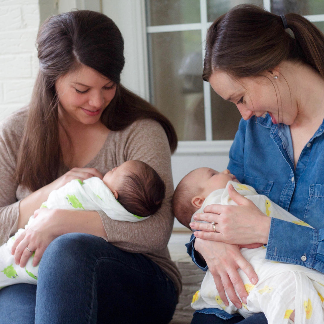 Mothers holding swaddled babies